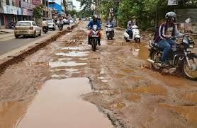 A damaged road filled with water and mud, illustrating the poor road conditions that will be reported via the new app for government intervention.