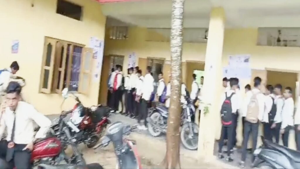 শিক্ষার্থীরা ক্যাম্পাসে দ্রুত গতিতে চলাচল করছে, তাদের মধ্যে কিছু ছাত্র ও ছাত্রী রয়েছে।
